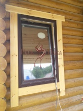 Фото. Окно с наличниками у дома из кругляка.