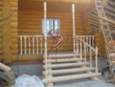 Срубленая вручную уличная лестница в срубе бревенчатого дома