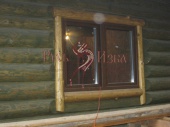 Фото отделки окна с обналичкой из деревянных полубревен. Таёжный стиль.